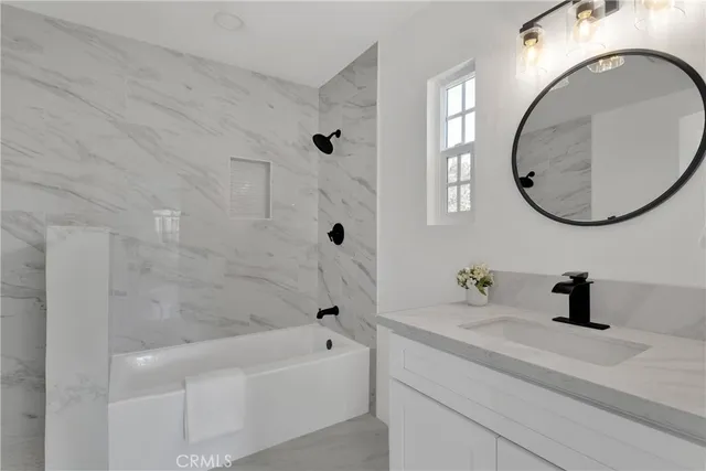 a bathroom with a sink a bathtub and a mirror