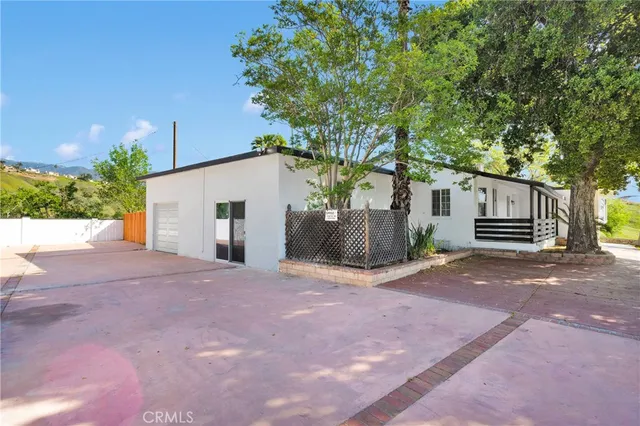 a view of a house with backyard and a tree