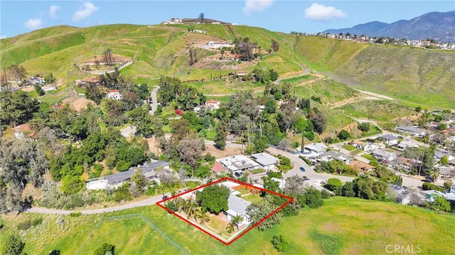 an aerial view of residential houses with outdoor space and trees