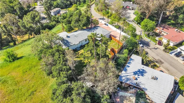 an aerial view of residential house with outdoor space and trees all around