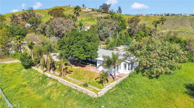 a view of a house with a big yard and large trees