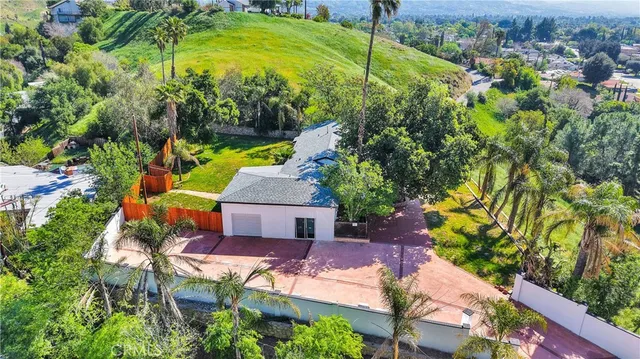 an aerial view of a house with a garden and lake view