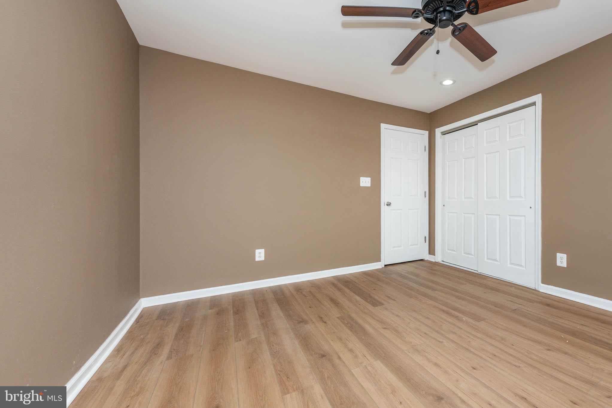 4021 Barrington Road Baltimore, MD 21207 - Photo 21 of 50 wooden floor in an empty room with a chandelier fan