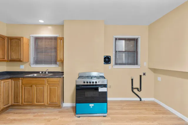 a living room with stainless steel appliances kitchen island granite countertop furniture and a wooden floor