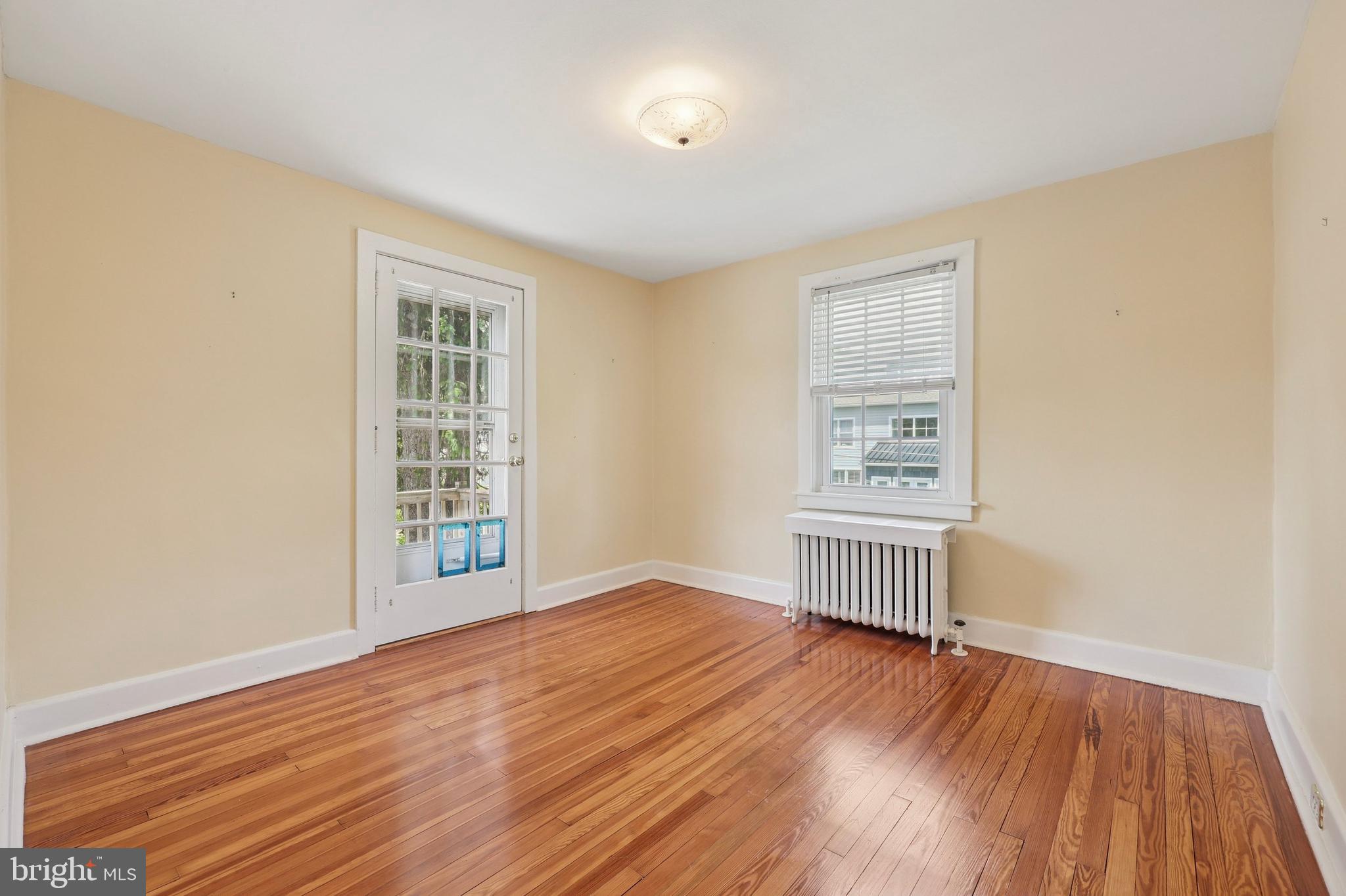 427 Righters Mill Road Gladwyne, PA 19035 - Photo 7 of 16 an empty room with wooden floor cabinet and windows