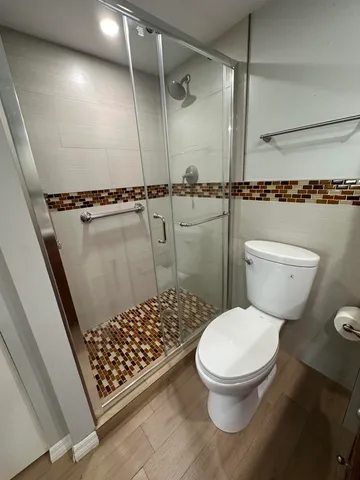 a bathroom with a toilet and a shower