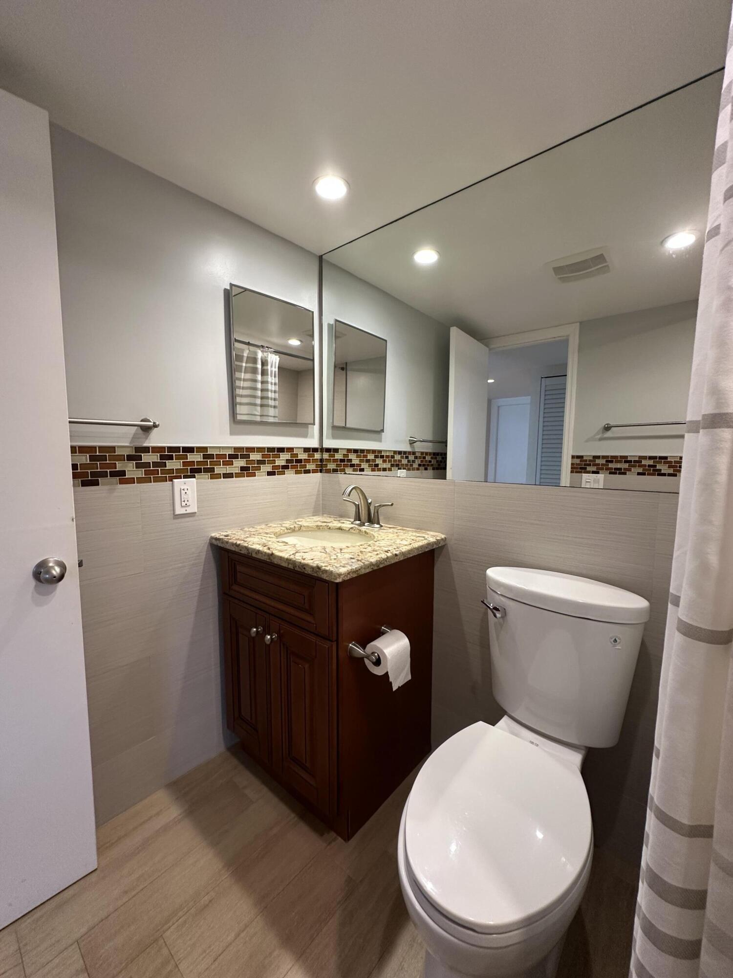3224 South Ocean Boulevard, Unit 310B Highland Beach, FL 33487 - Photo 17 of 26 a bathroom with a granite countertop toilet sink and mirror