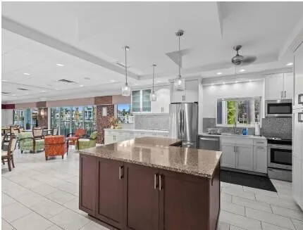 a kitchen with stainless steel appliances granite countertop a refrigerator a sink a stove and island