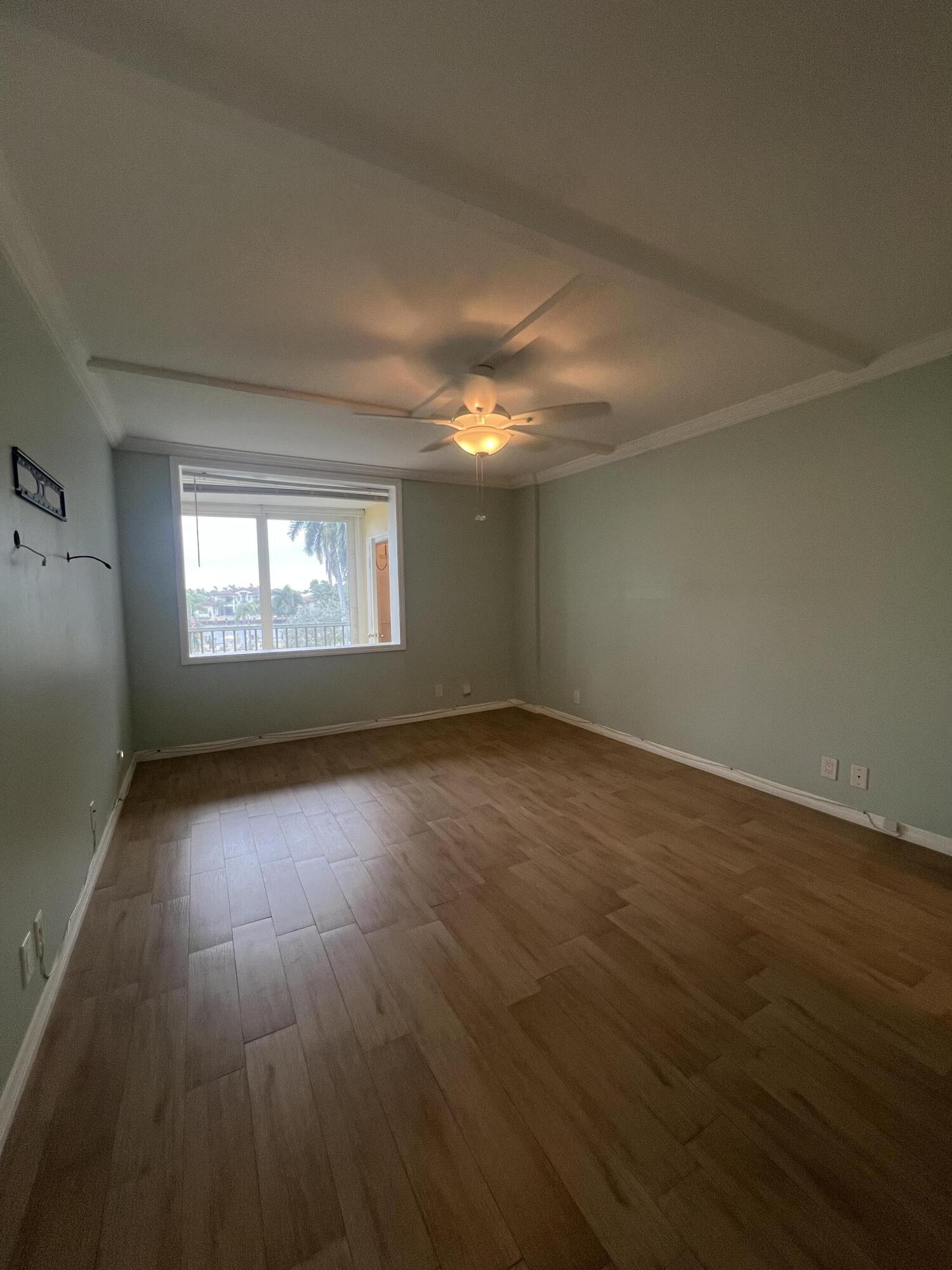 3224 South Ocean Boulevard, Unit 310B Highland Beach, FL 33487 - Photo 8 of 26 an empty room with wooden floor and windows
