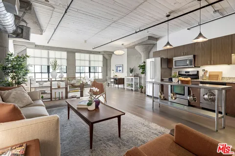 a living room with furniture a wooden floor and a large window
