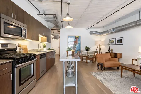 a living room with furniture a flat screen tv and kitchen view