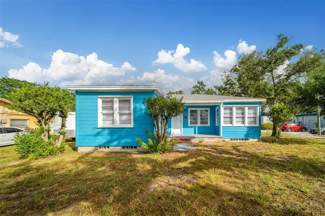 a front view of house with yard and trees in the background
