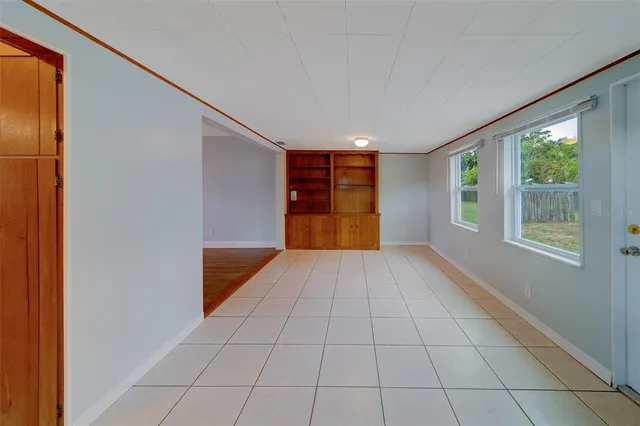 a view of an empty room with window and closet area