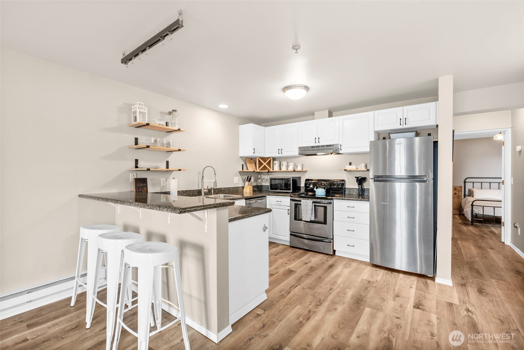 218 Broadway, Unit 5 Tacoma, WA 98402 - Photo 3 of 32 a kitchen with white cabinets and stainless steel appliances