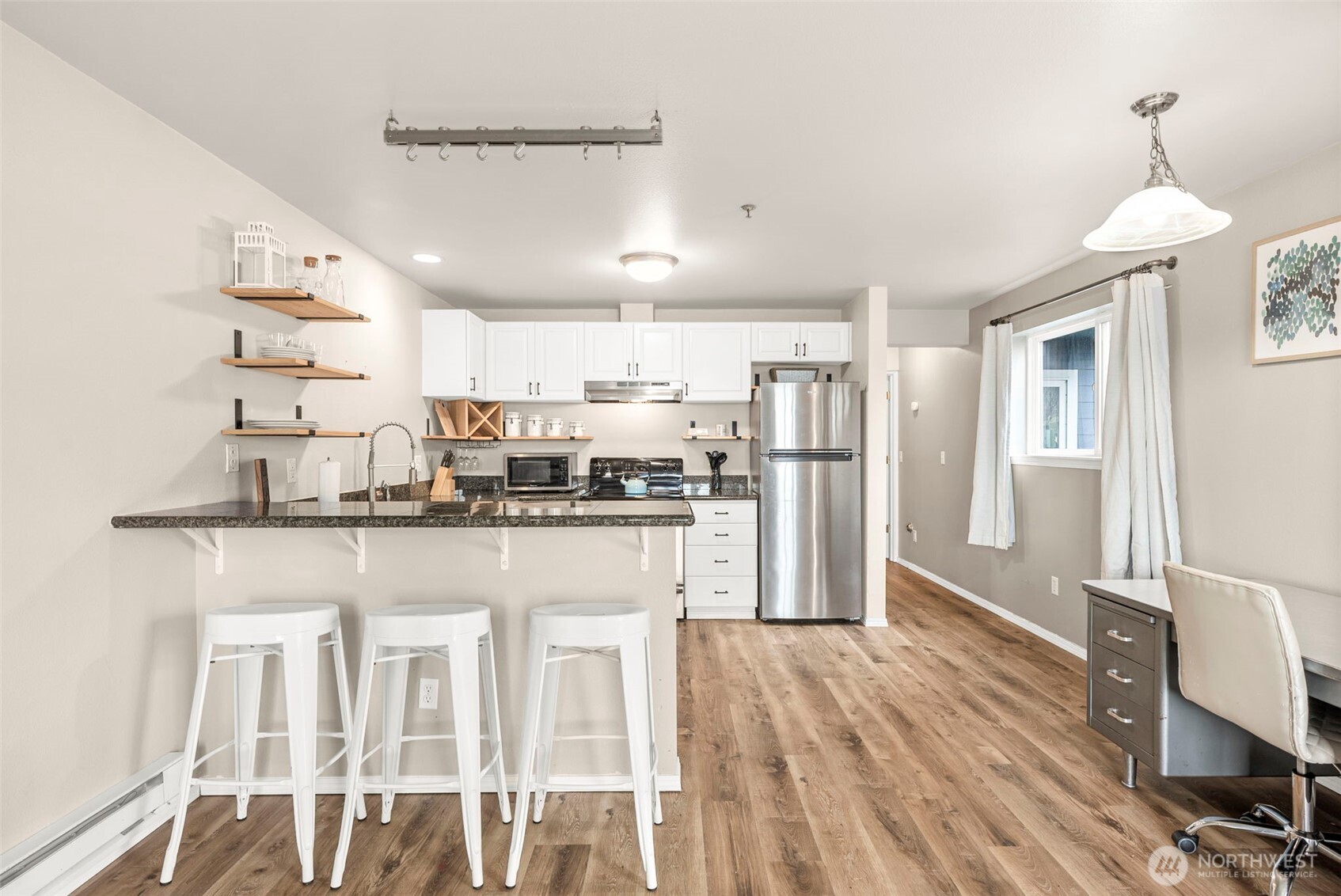218 Broadway, Unit 5 Tacoma, WA 98402 - Photo 9 of 32 a kitchen with stainless steel appliances granite countertop a refrigerator a stove a sink dishwasher and white cabinets with wooden floor