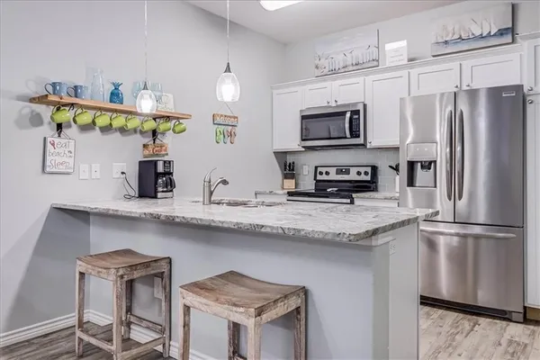 a kitchen with stainless steel appliances granite countertop a refrigerator and a stove top oven