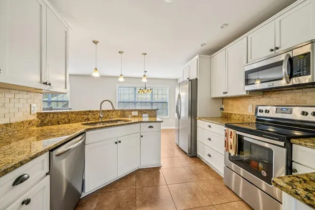 a kitchen with stainless steel appliances granite countertop a sink and stove top oven