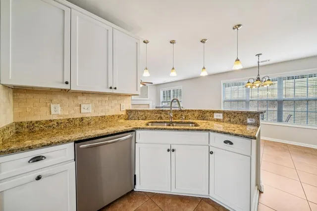 a kitchen with granite countertop a sink a stove and cabinets