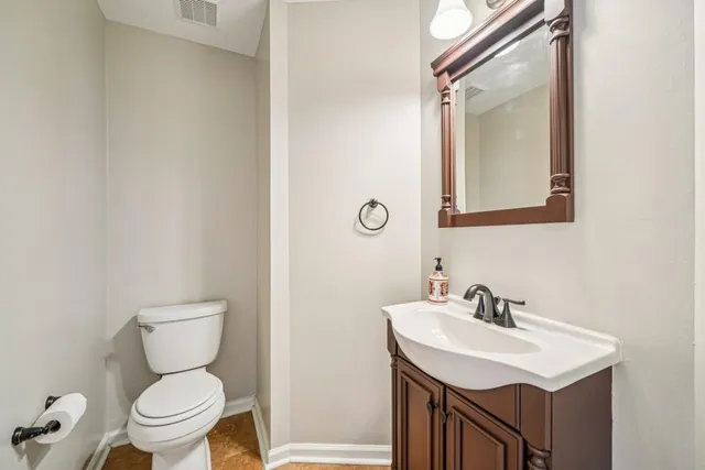 a bathroom with a toilet a sink and a mirror