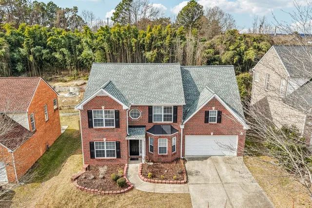 an aerial view of a house with a mountain