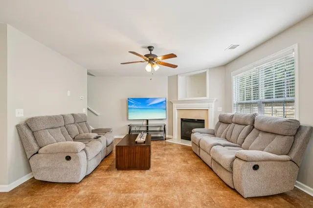 a living room with furniture a fireplace and a large window