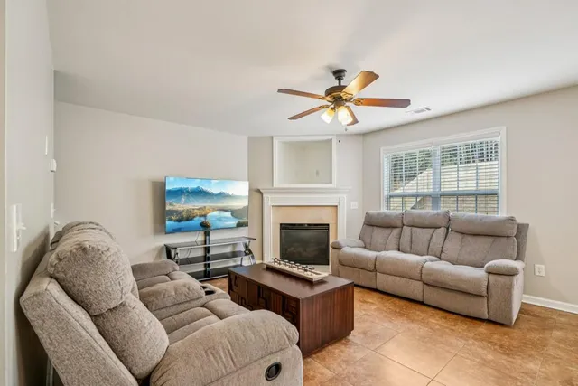 a living room with furniture a fireplace and a flat screen tv