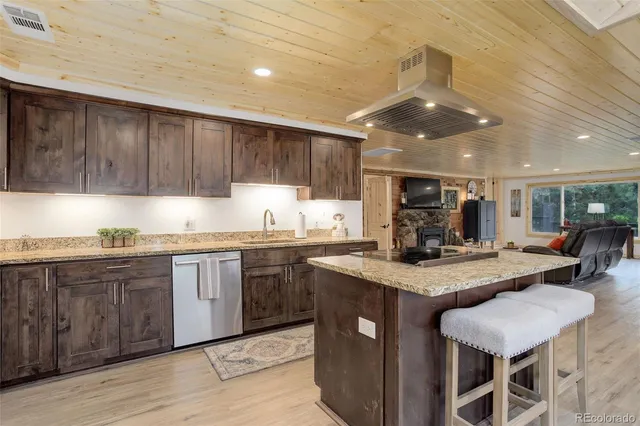 a kitchen with stainless steel appliances granite countertop a sink counter space and a refrigerator