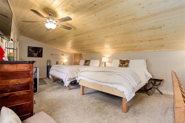 a spacious bedroom with a bed and a chandelier