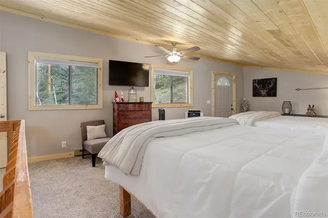 a bed room with a bed a television and a large window