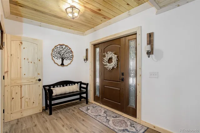a view of a hallway with wooden floor and a chandelier