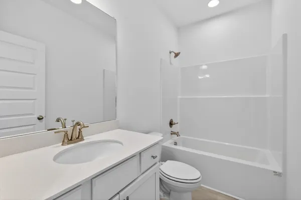 a bathroom with a sink toilet vanity and shower