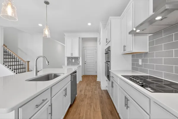 a kitchen with sink a stove and cabinets