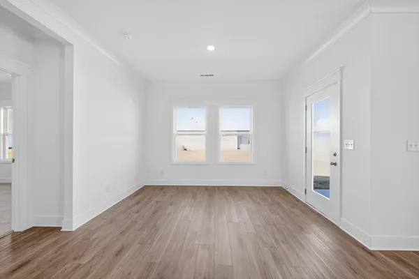 a view of a kitchen with wooden floor and a window