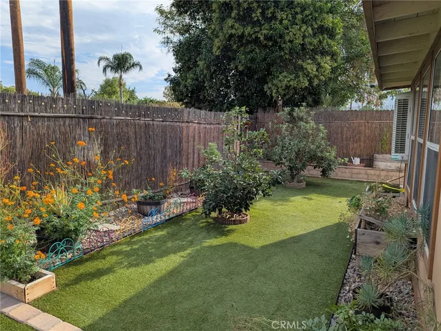 a view of a backyard with plants and a bench