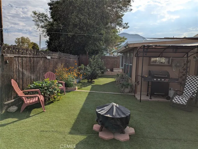 a patio with table and chairs and potted plants