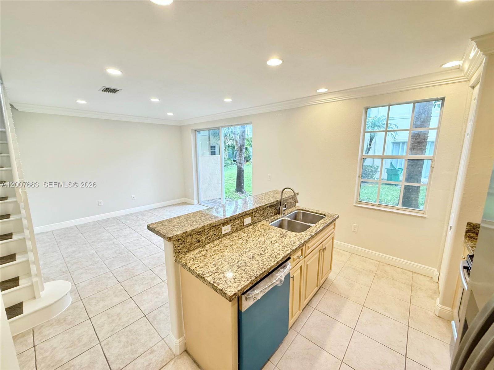 2674 Southwest 84th Terrace, Unit 102 Miramar, FL 33025 - Photo 11 of 57 a hall with kitchen island granite countertop a sink and a stove