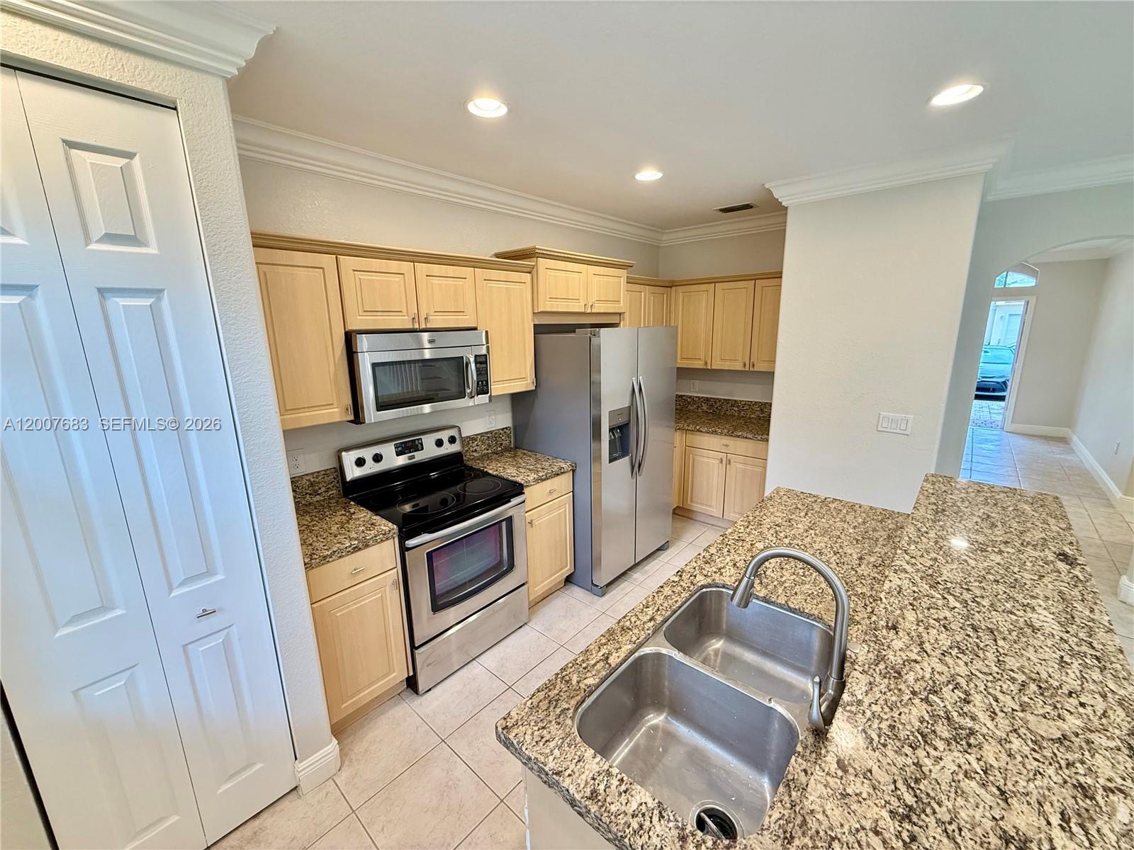 2674 Southwest 84th Terrace, Unit 102 Miramar, FL 33025 - Photo 13 of 57 a kitchen with granite countertop a sink and stainless steel appliances