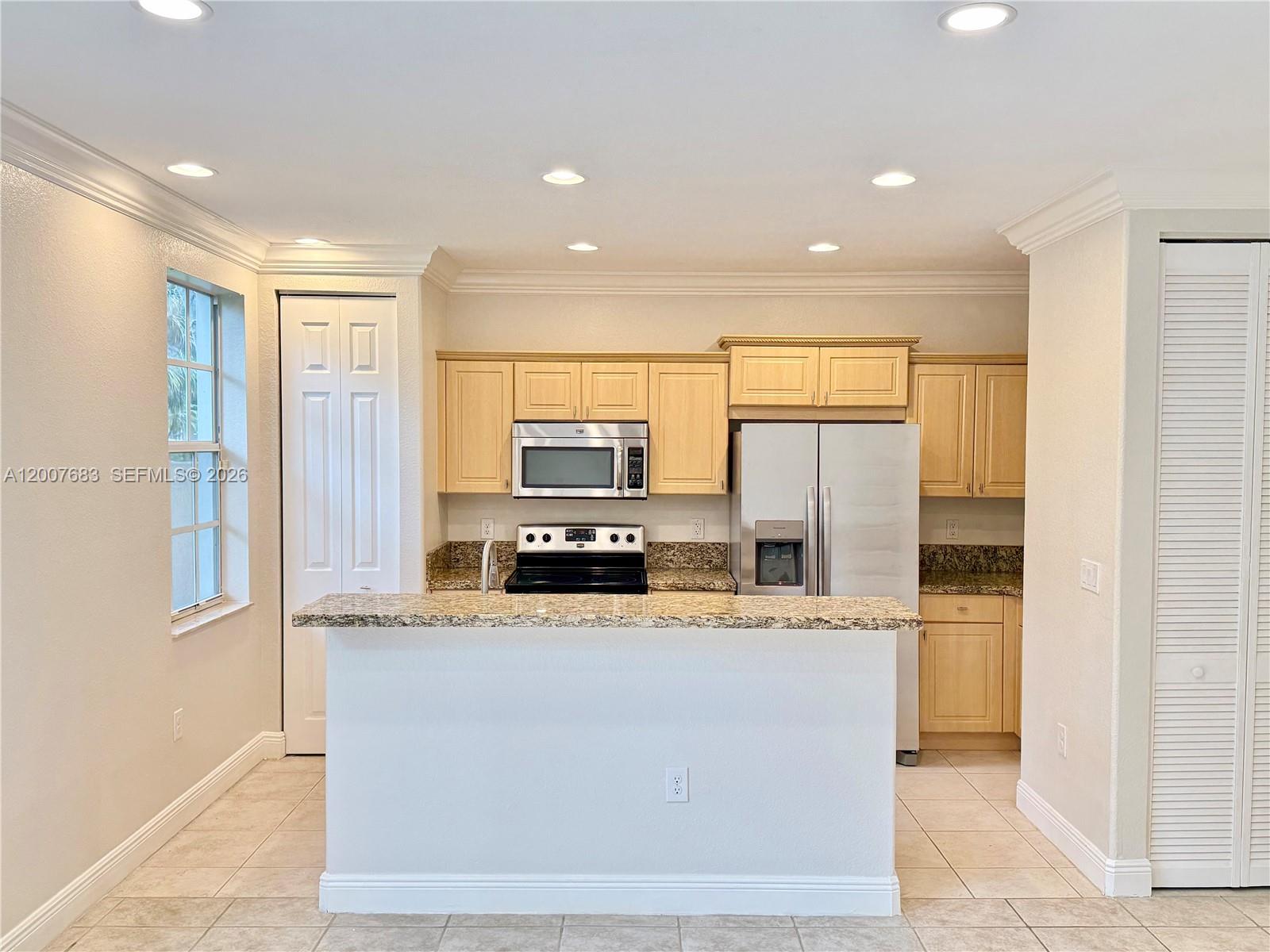2674 Southwest 84th Terrace, Unit 102 Miramar, FL 33025 - Photo 14 of 57 a kitchen with stainless steel appliances a refrigerator and a stove top oven