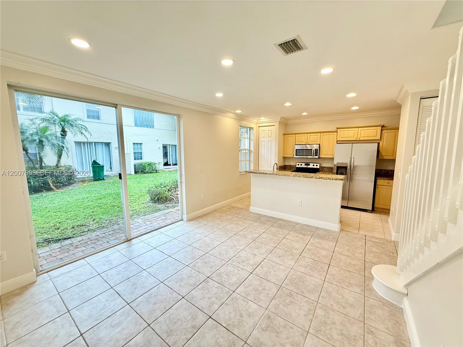 2674 Southwest 84th Terrace, Unit 102 Miramar, FL 33025 - Photo 15 of 57 a view of a kitchen with kitchen island stainless steel appliances refrigerator sink and cabinets