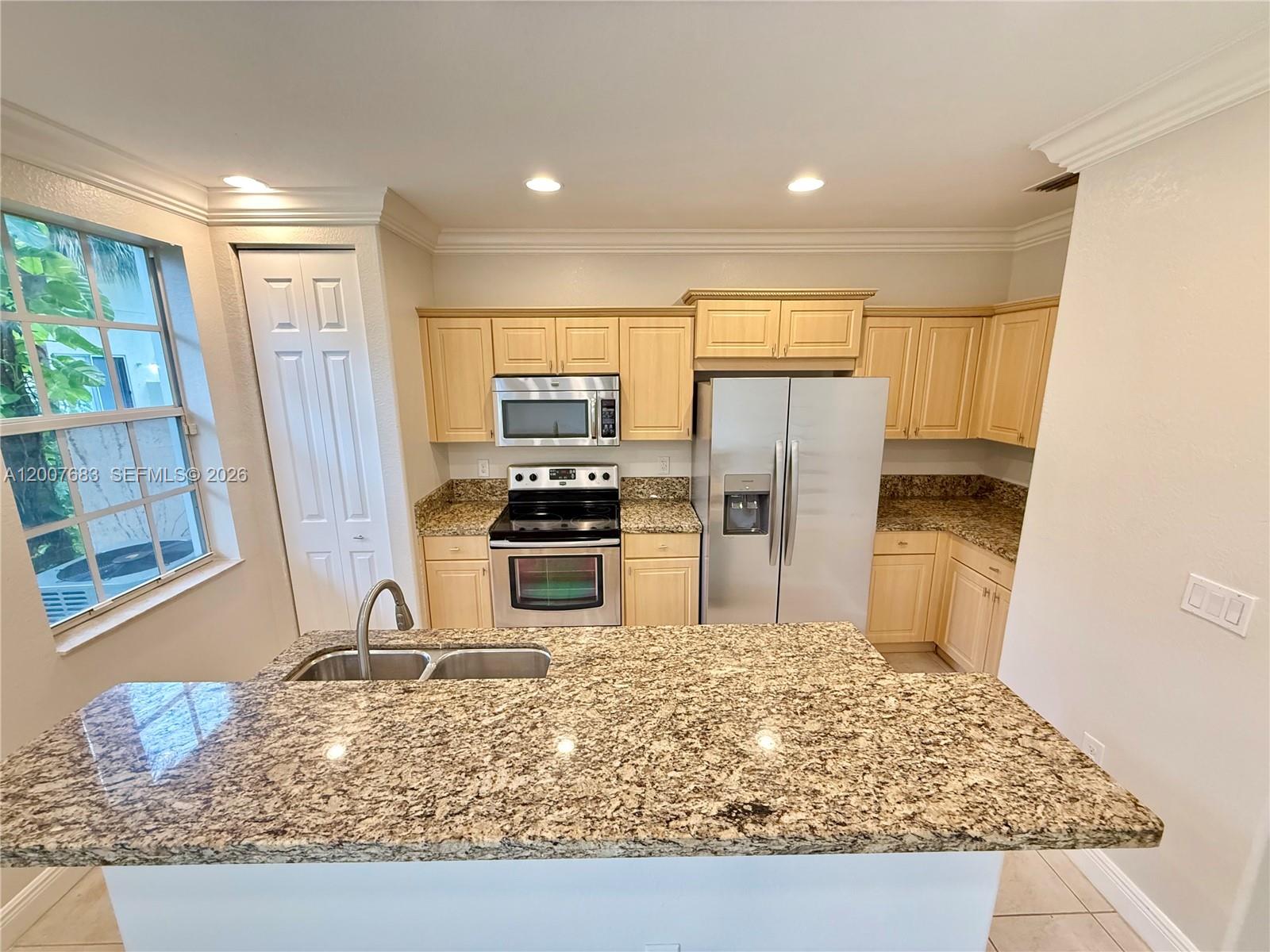 2674 Southwest 84th Terrace, Unit 102 Miramar, FL 33025 - Photo 2 of 57 a kitchen with stainless steel appliances granite countertop a refrigerator oven stove a sink and dishwasher