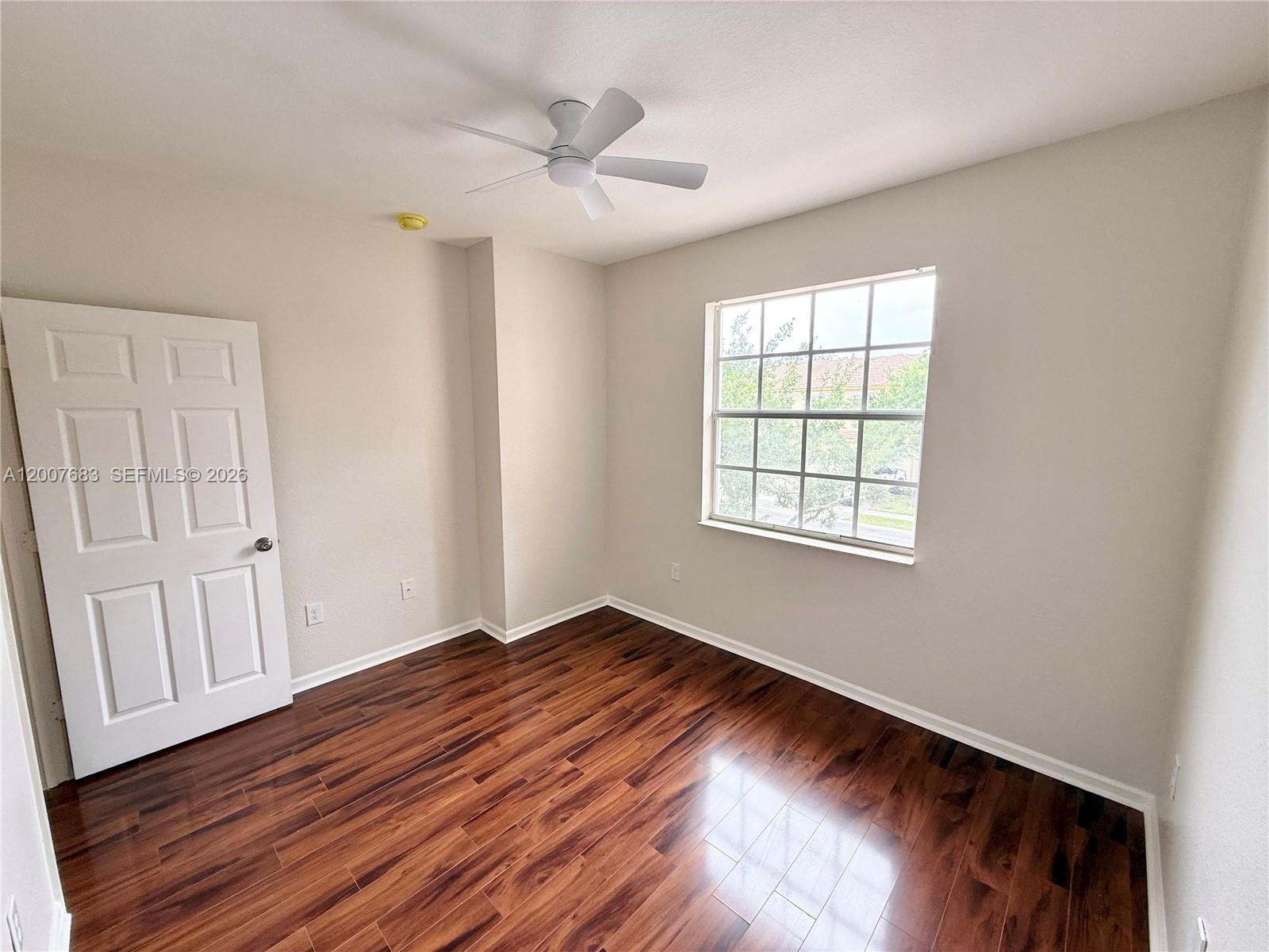 2674 Southwest 84th Terrace, Unit 102 Miramar, FL 33025 - Photo 27 of 57 a view of an empty room with wooden floor and a window