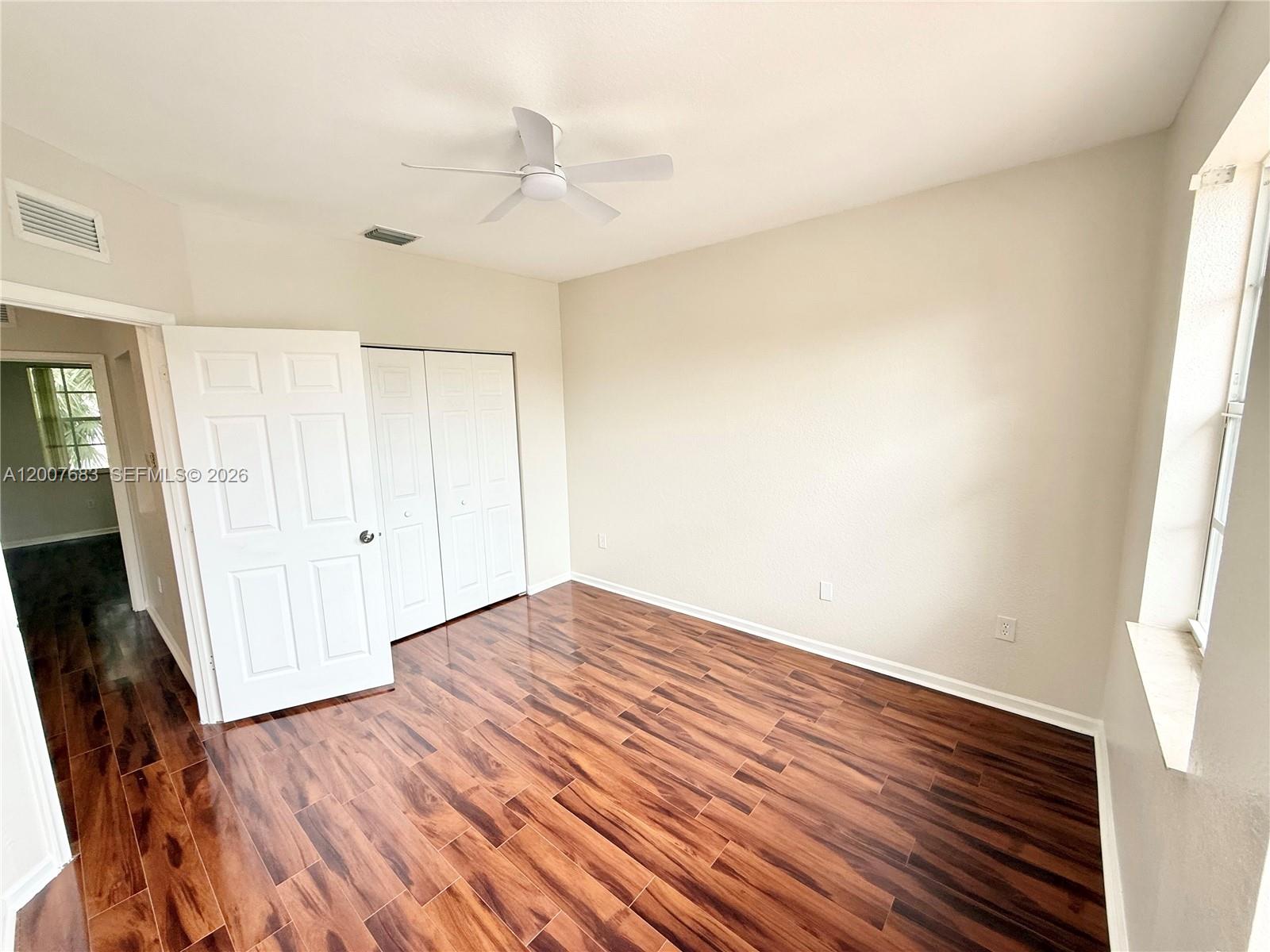 2674 Southwest 84th Terrace, Unit 102 Miramar, FL 33025 - Photo 28 of 57 an empty room with wooden floor and windows