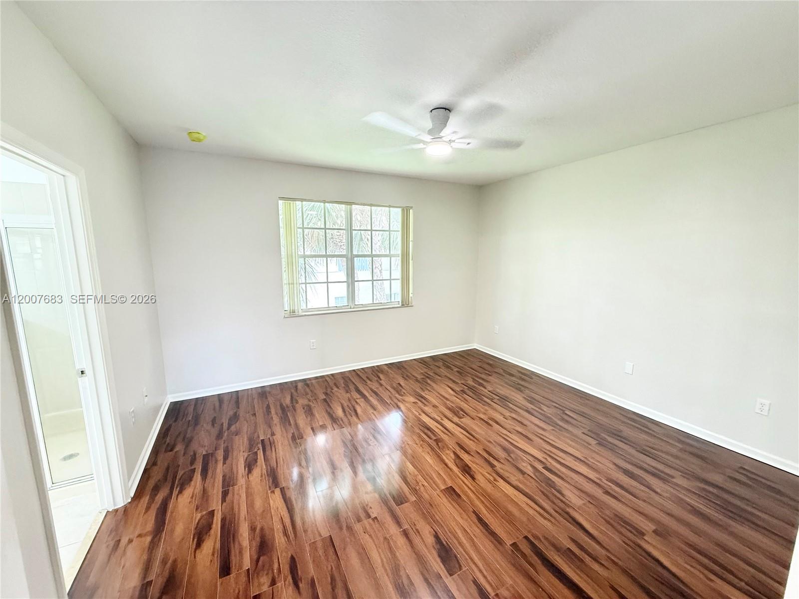 2674 Southwest 84th Terrace, Unit 102 Miramar, FL 33025 - Photo 34 of 57 an empty room with wooden floor cabinet and windows