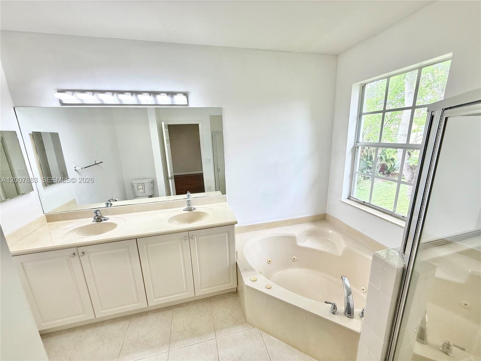 2674 Southwest 84th Terrace, Unit 102 Miramar, FL 33025 - Photo 40 of 57 a bathroom with a tub sink and mirror