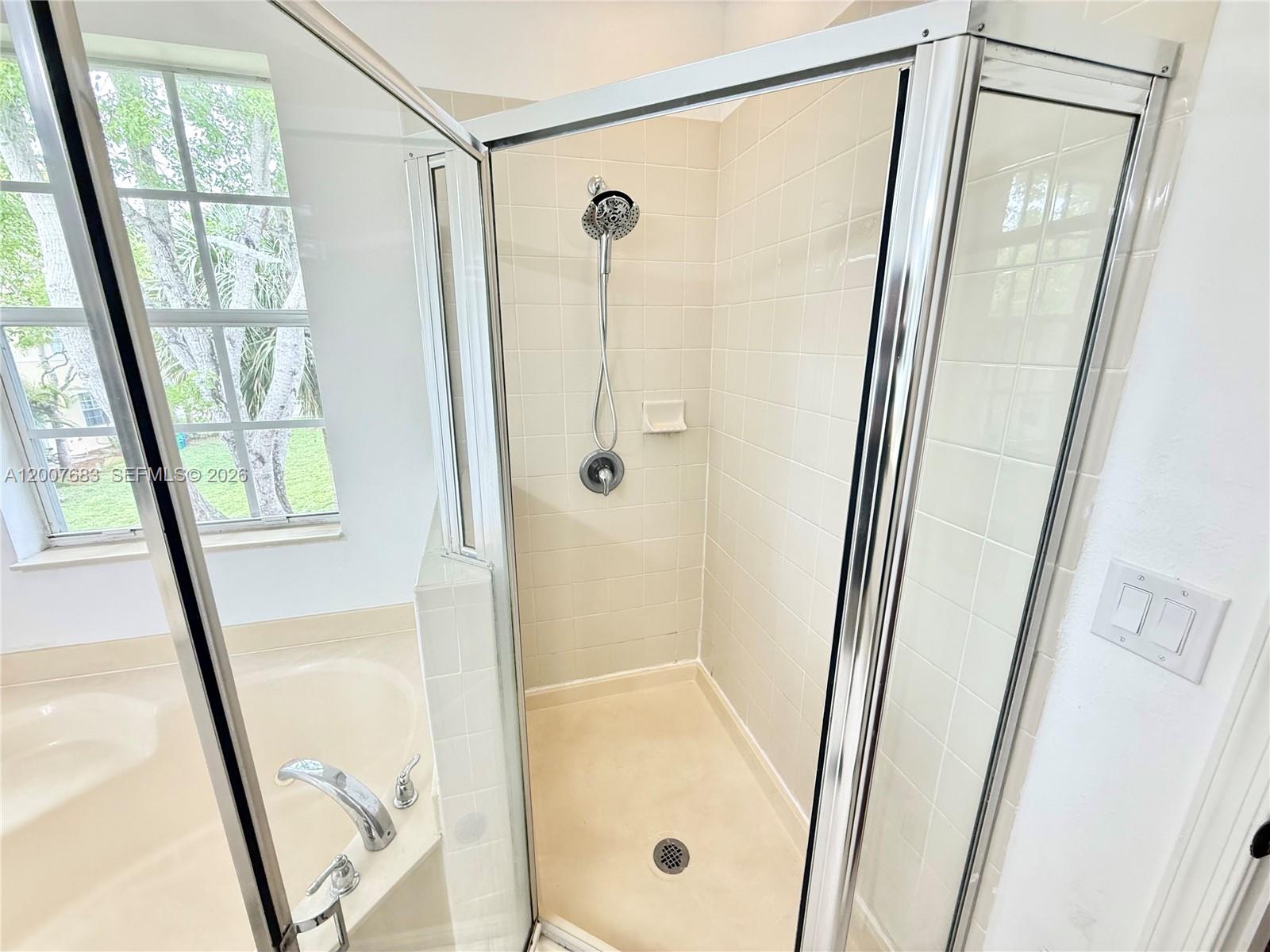 2674 Southwest 84th Terrace, Unit 102 Miramar, FL 33025 - Photo 41 of 57 a bathroom with a glass shower door and a window