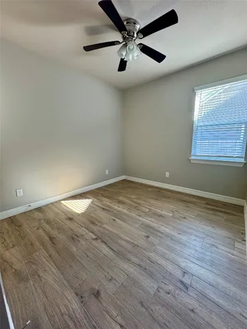 an empty room with closet and a ceiling fan