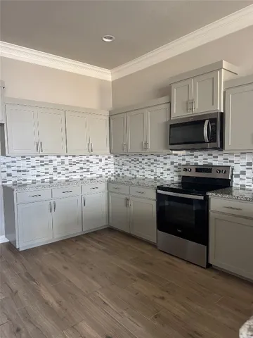 a view of a kitchen with kitchen island white cabinets and wooden floor