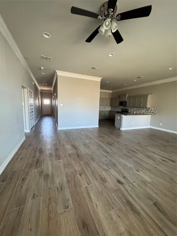 a kitchen with stainless steel appliances kitchen island granite countertop a sink cabinets and wooden floor