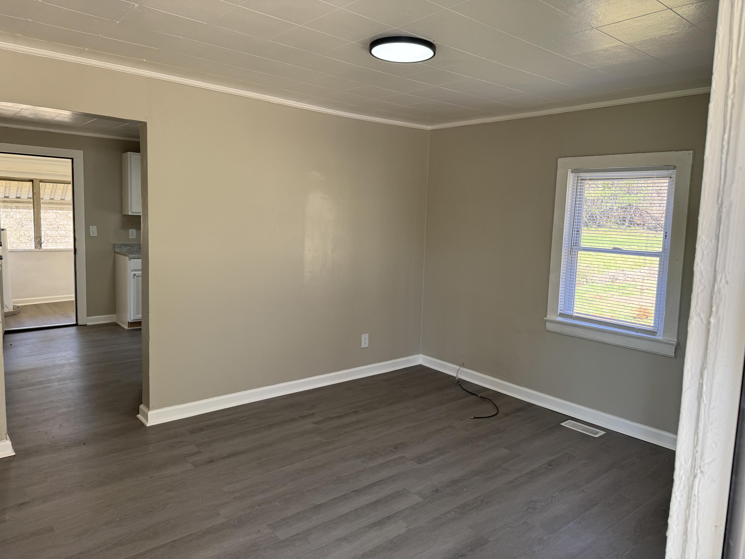 705 Barrows Mill Road Martinsville, VA 24112 - Photo 3 of 7 an empty room with wooden floor and windows