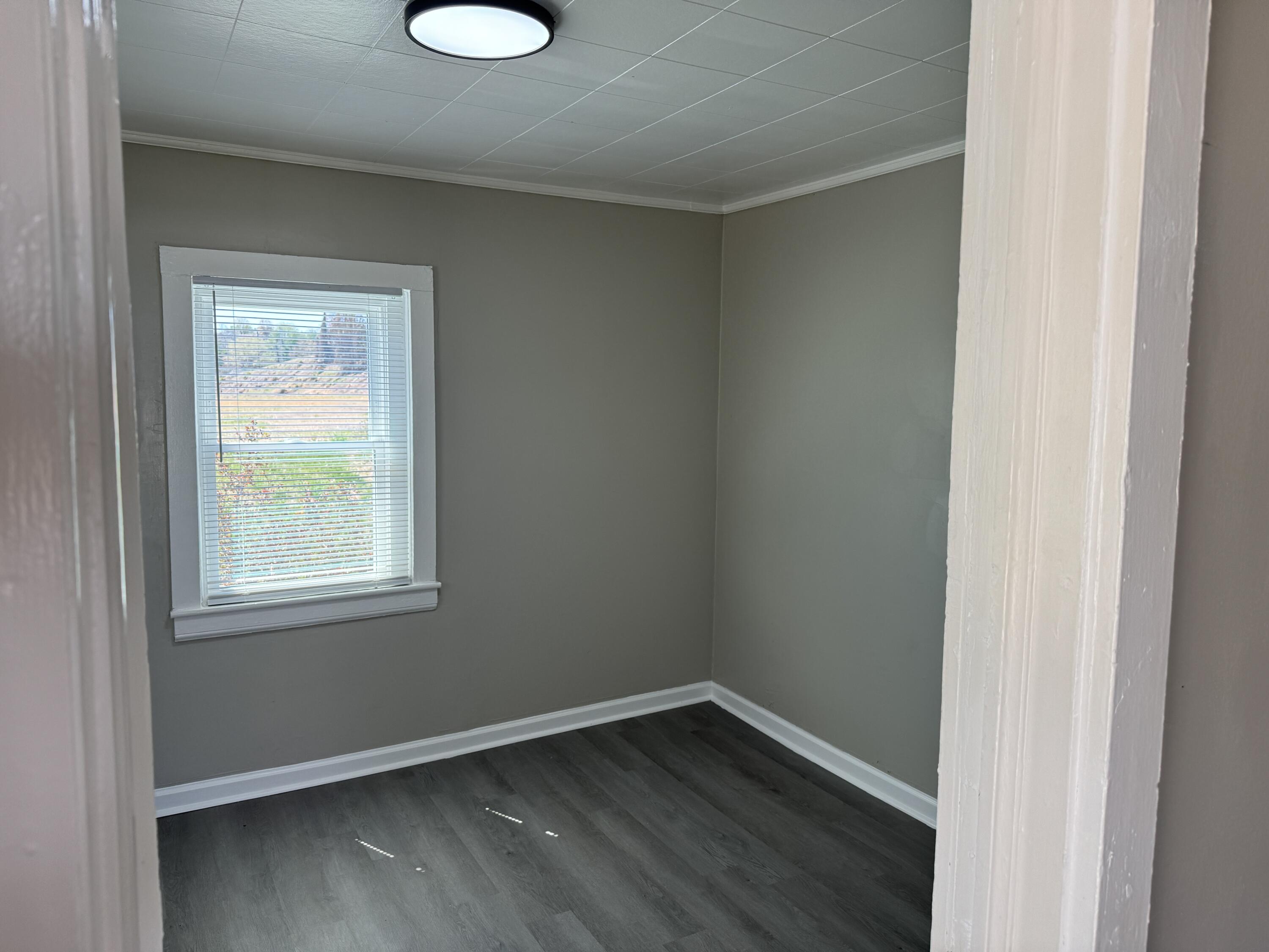 705 Barrows Mill Road Martinsville, VA 24112 - Photo 4 of 7 an empty room with wooden floor and windows